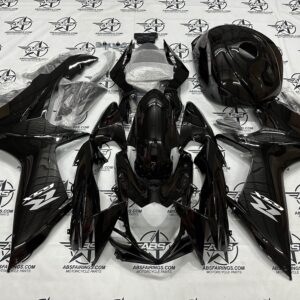 Black motorcycle fairings set laid out on table.