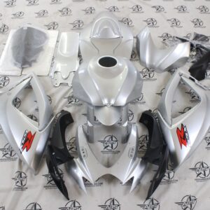 Silver motorcycle fairing kit laid out on floor.