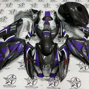 Disassembled motorcycle fairings and helmet on patterned background.