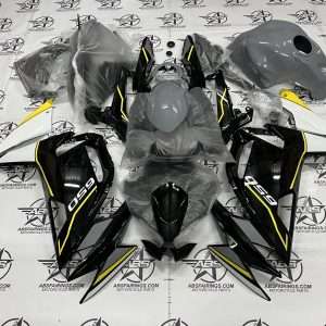 Disassembled motorcycle fairing kit on branded workshop floor.
