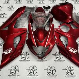 Red motorcycle fairings laid out on the floor.