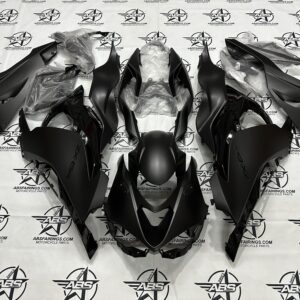Black motorcycle fairings set laid out on table.