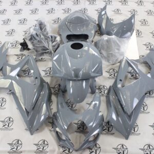Gray motorcycle fairings on logo-covered surface.