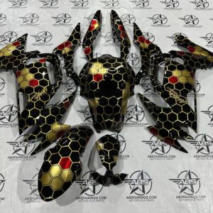 Motorcycle fairings with hexagonal red and gold design.